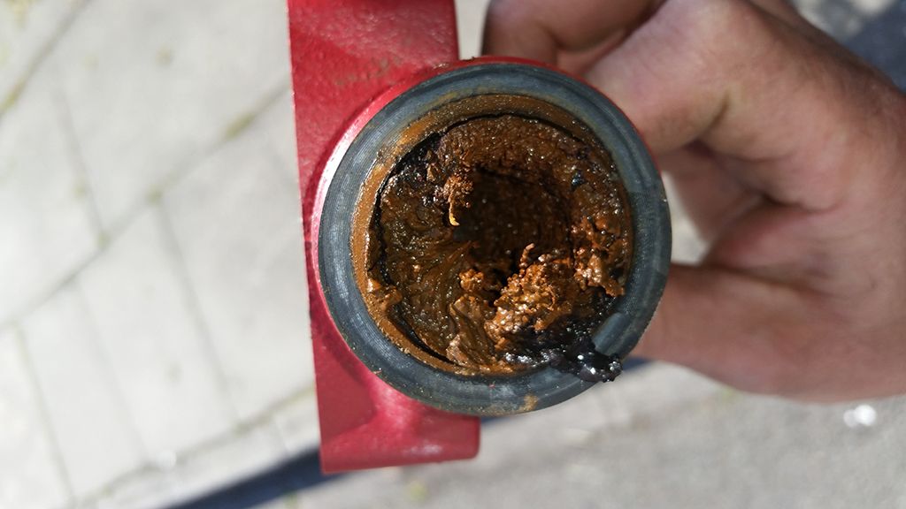 Photo showing a buildup of sludge inside a pipe. Power flushing can prevent this buildup from happening.